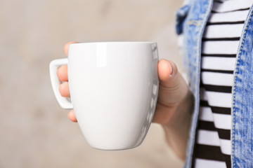 Blank white cup in hand, closeup