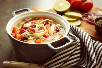 Chicken tortilla soup with vegetables on kitchen table