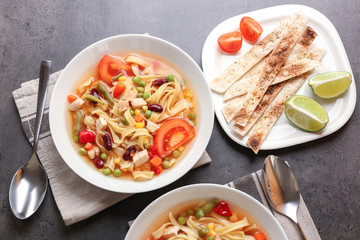 Chicken tortilla soup in plate on kitchen table
