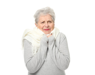 Portrait of elderly woman feeling cold on white background