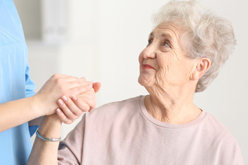 Elderly woman listening doctor in light room