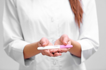 Doctor holding pregnancy test, closeup