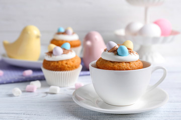 Delicious cupcake in cup on wooden table