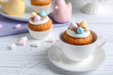 Delicious cupcake in cup on wooden table