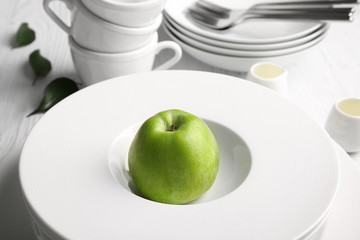 Composition with fresh apple in white ceramic bowl, close up