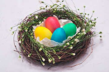 Easter eggs in beautiful nest on marble background.