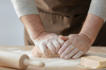 Obraz na płótnie Canvas Hands of man making dough in kitchen