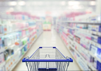 Abstract blurred photo of  cosmetic area in supermarket with empty shopping cart shopping concept.