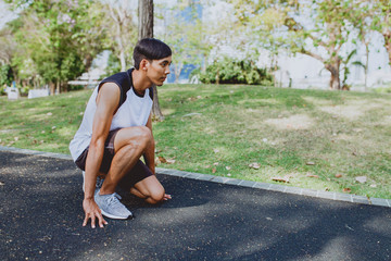 Man preparing to run in park.