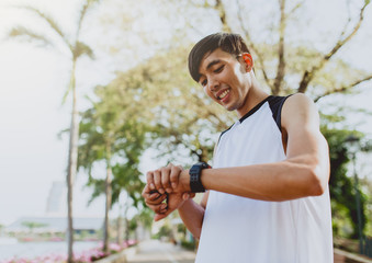 Fototapeta premium Athlete man is looking at smart watch.