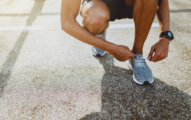 Running shoes, Close up of runner man trying shoelaces getting ready for run on the outdoor street. Sport and exercise concept