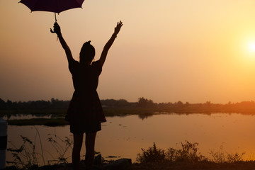 Fototapeta premium Silhouette of woman praying over beautiful sky sunset background 
