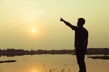 Fototapeta premium Silhouette of man praying over beautiful sky sunset background 