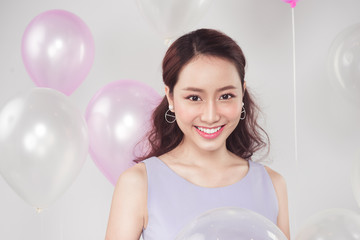 Stylish beautiful asian woman with pastel balloons