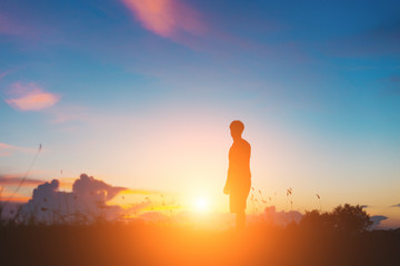 Silhouette of jumping man on sunrise background. The concept happy.