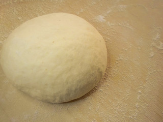the dough and flour on a wooden board
