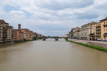 Fototapeta na wymiar Bridge on the river Arno in Florence, Italy with colorful rustic buildings on the edge