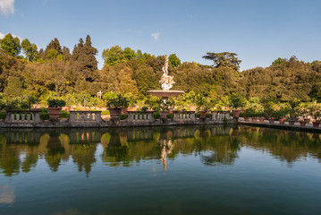 Italian garden with mediterranean plants reflecting in the lake
