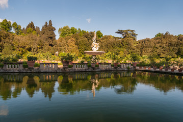 Fototapeta na wymiar Italian garden with mediterranean plants reflecting in the lake