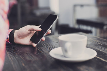 Young man using smartphone in a cafe