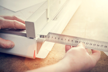 Man does measuring with slide calliper in paper cutter