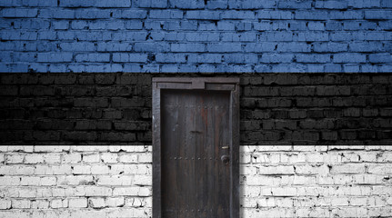 Fototapeta na wymiar Estonia flag on brick wall. Closed door in a wall