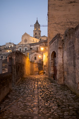 Old town of Matera. Cobble stoned alley with the Cathedral in the background