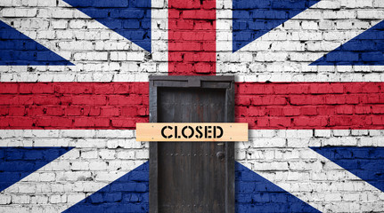 England flag on brick wall with closed door and Closed sign