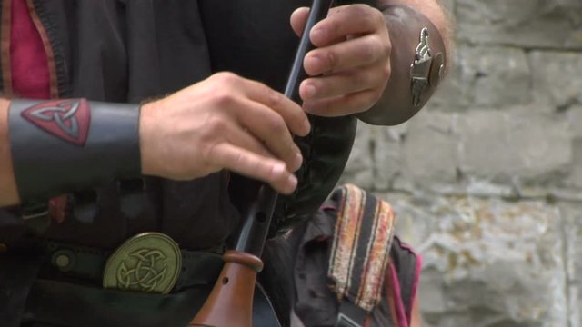 Close up of a medieval musician playing a bagpipe