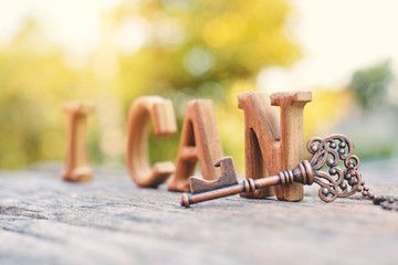 alphabet wood "I can" word on tree bokeh background, selective and soft focus