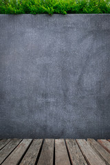 Old wooden planks with concrete wall or marble wall and ornamental plants or ivy or garden tree for background.