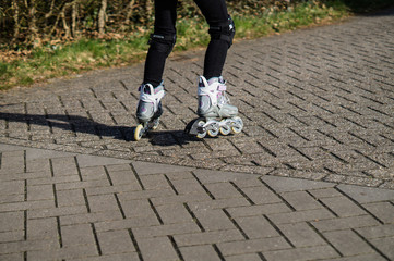 Fototapeta na wymiar Children ride on inline skates on the street