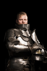 Fototapeta na wymiar Knight in armour after battle on the black background