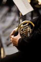 Musician in the orchestra closeup wielding french horn