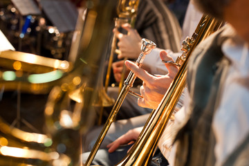 The hand of a musician holding a trombone closeup