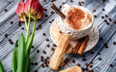 Lovely latte macchiato on a wooden background with cookies and cinnamon