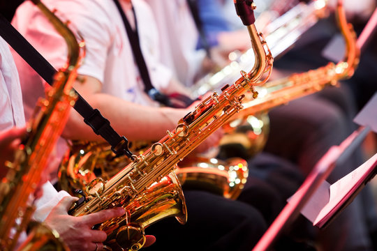  Saxophone in the hands of a musician in an orchestra closeup