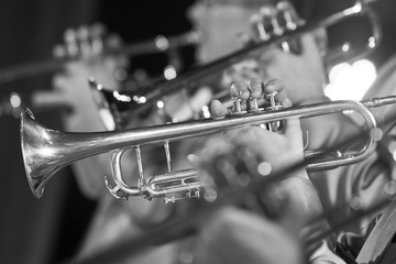 Hands of man playing the trumpet in the orchestra in black and white
