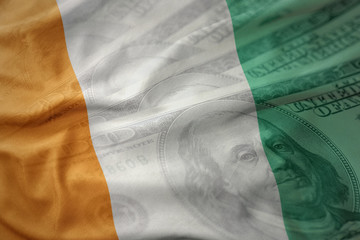 colorful waving national flag of cote divoire on a american dollar money background.