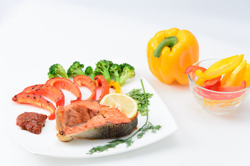 Grilled red fish with sauce, broccoli, parsley and dill  on a white plate