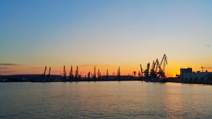 Sunset over sea port and industrial cranes. Varna.