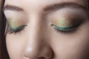 cocktail makeup closeup on closed eyes girl with clean skin. The green tones.Macro.