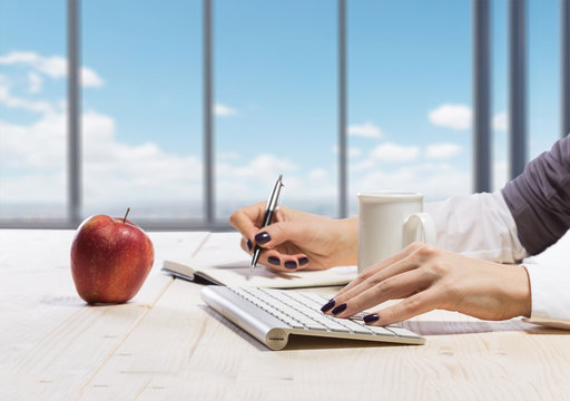 Business woman in an office holding red apple - Clipping Path - Powered by Adobe
