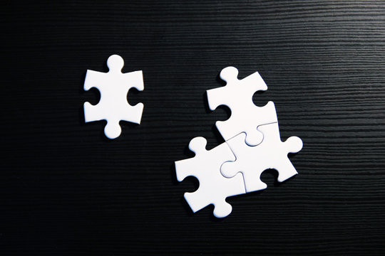 Viertes Puzzleteil (wei&szlig;) vervollst&auml;ndigt auf schwarzem Grund