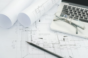 black pencil and computer laptop on architectural drawing paper for construction