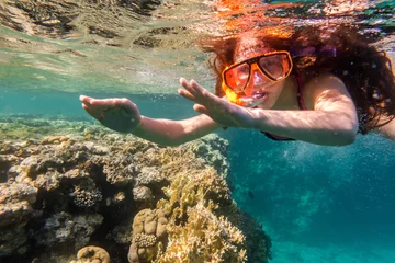 Fotobehang Meisje met zwemmasker duikt in de Rode Zee bij koraalrif © Sergiy Bykhunenko