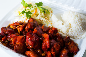 Vietnamese cuisine. meat, fried. packed in a box, disposable tableware. concept of fast food takeaway. Asian meat. Convenient but unhealthy polystyrene lunch boxes with take away meal on wooden table