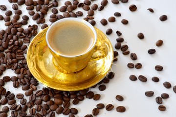 Goldene Tasse mit Kaffee und Kaffeebohnen mit Sterneffekt