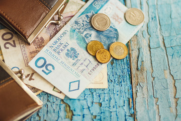 Polish zloty with little wallets on the old wooden background