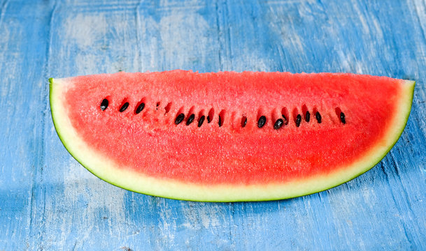 Watermelon slice on blue wooden .